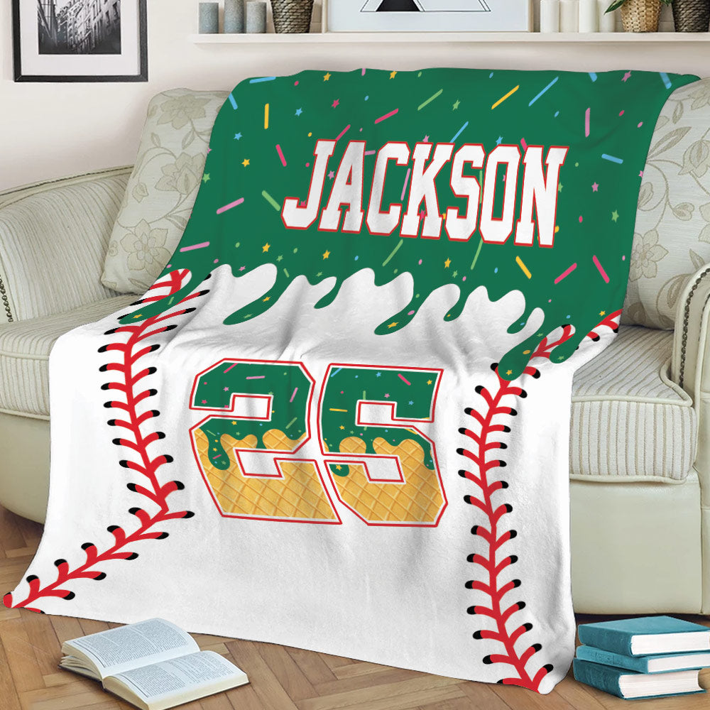 Baseball blanket displayed on a sofa with green sports artwork, baseball seam borders, and a bold jersey-inspired design