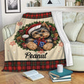 Yorkie holiday throw blanket draped over a sofa with wreath artwork, wrapped gift and red plaid border