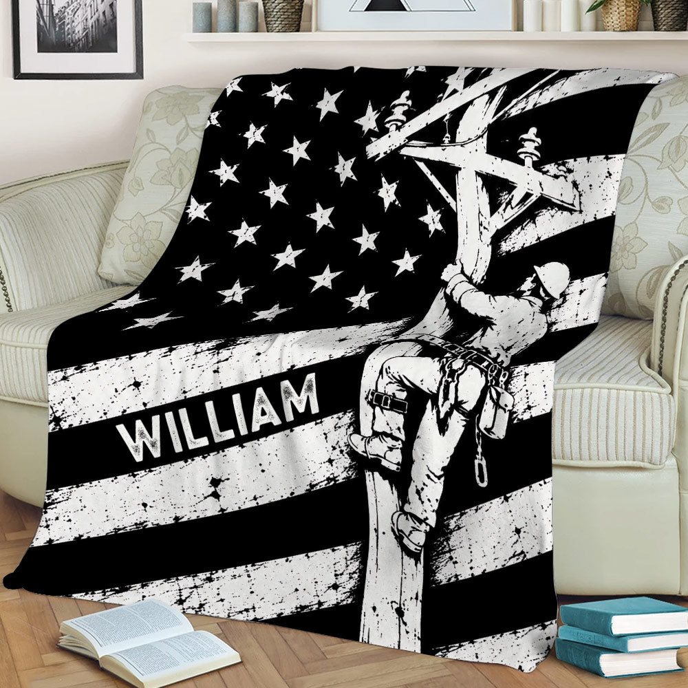 Custom lineman blanket draped over a couch with a utility worker climbing a pole in bold flag-inspired artwork