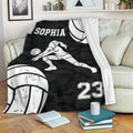 Volleyball throw blanket draped over a couch with a female player design and black camouflage background