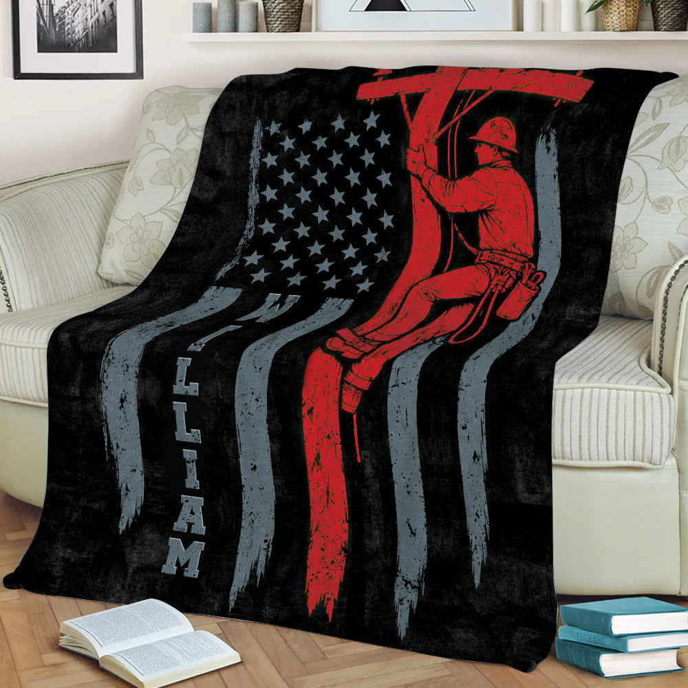 Lineman throw blanket displayed on a couch with bold red, black and gray utility worker artwork