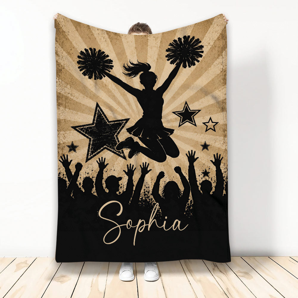 Cheerleading throw blanket with jumping cheerleader silhouette, pom-poms, stars, and cheering crowd artwork