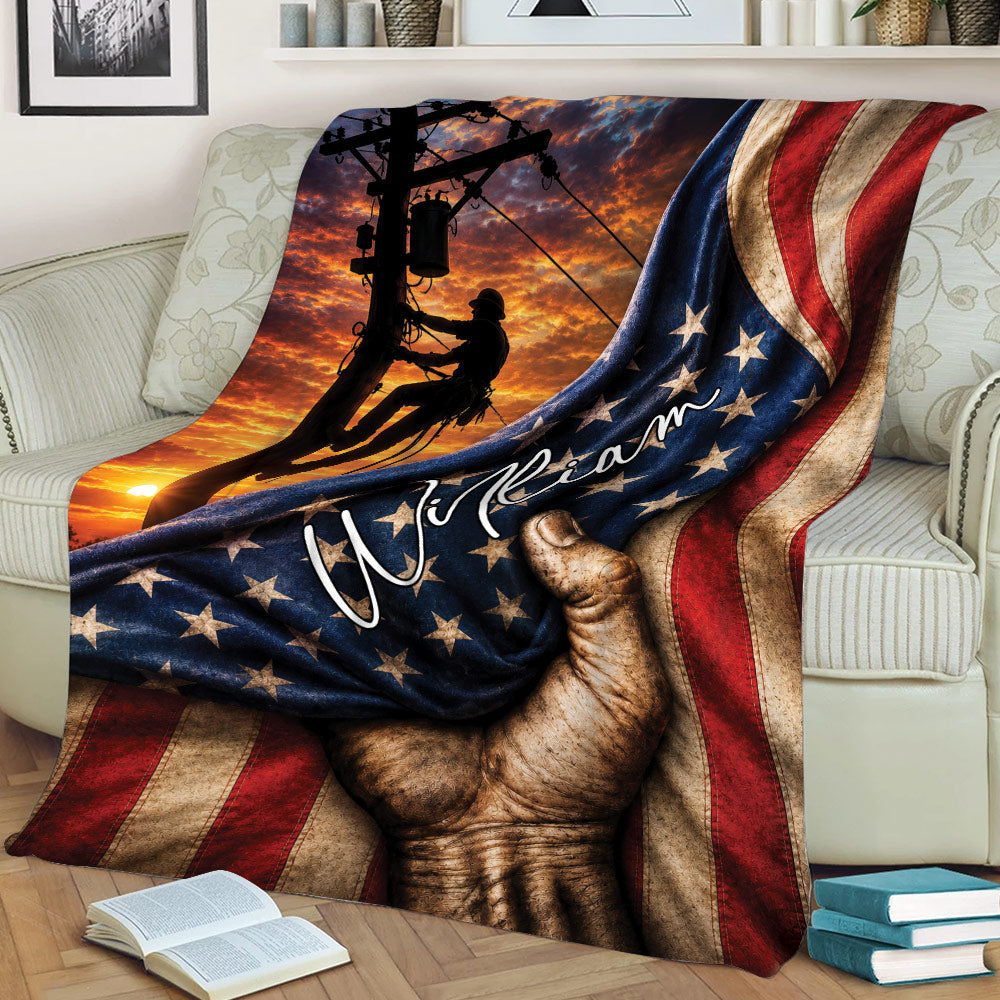 Lineman throw blanket displayed on a couch with power line artwork, sunset colors, and flag accents