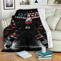 Hockey throw blanket displayed on a sofa with a dramatic goalie design in black, red and white