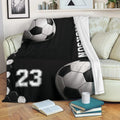 Custom soccer throw blanket with black and white ball design draped over a sofa