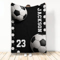 Black and white soccer ball artwork on a custom soccer blanket displayed in a room