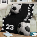 Soccer-themed throw blanket with bold black and white ball artwork on a couch