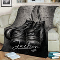 Close lifestyle view of black boxing glove artwork on a throw blanket across a sofa