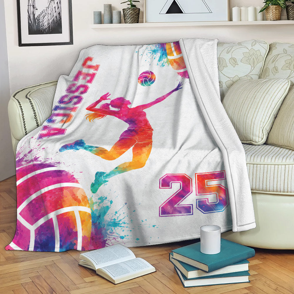 Volleyball throw blanket draped over a sofa with colorful player silhouette and artistic ball design