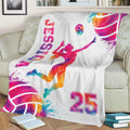 Vibrant volleyball blanket displayed on a couch with female athlete artwork and colorful sports splashes