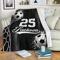 Black and white soccer blanket draped over a sofa with bold sports artwork