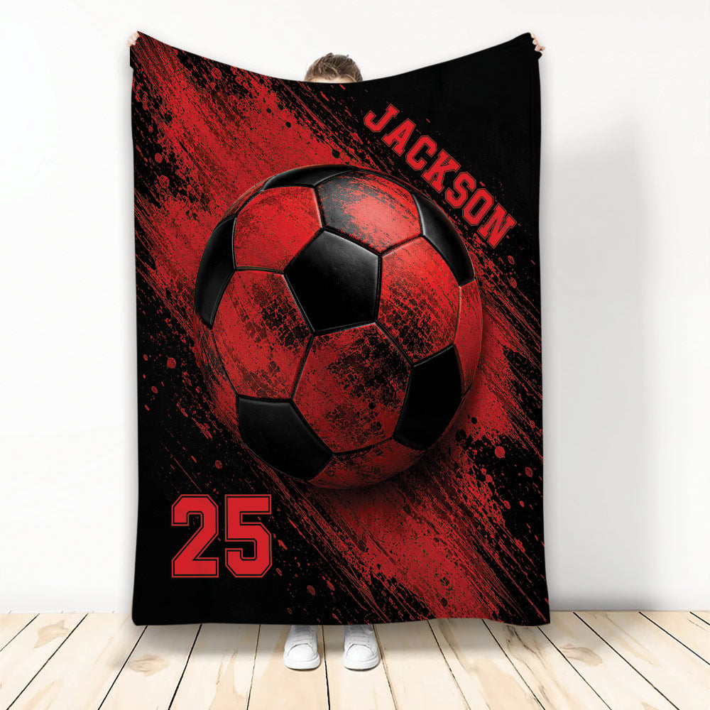 Red and black soccer throw blanket displayed vertically with bold ball artwork and splatter-style sports graphics
