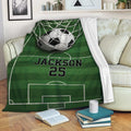 Soccer throw blanket draped across a sofa with green field markings and goal artwork