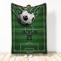 Soccer blanket displayed vertically with a ball in the goal net over a green field design