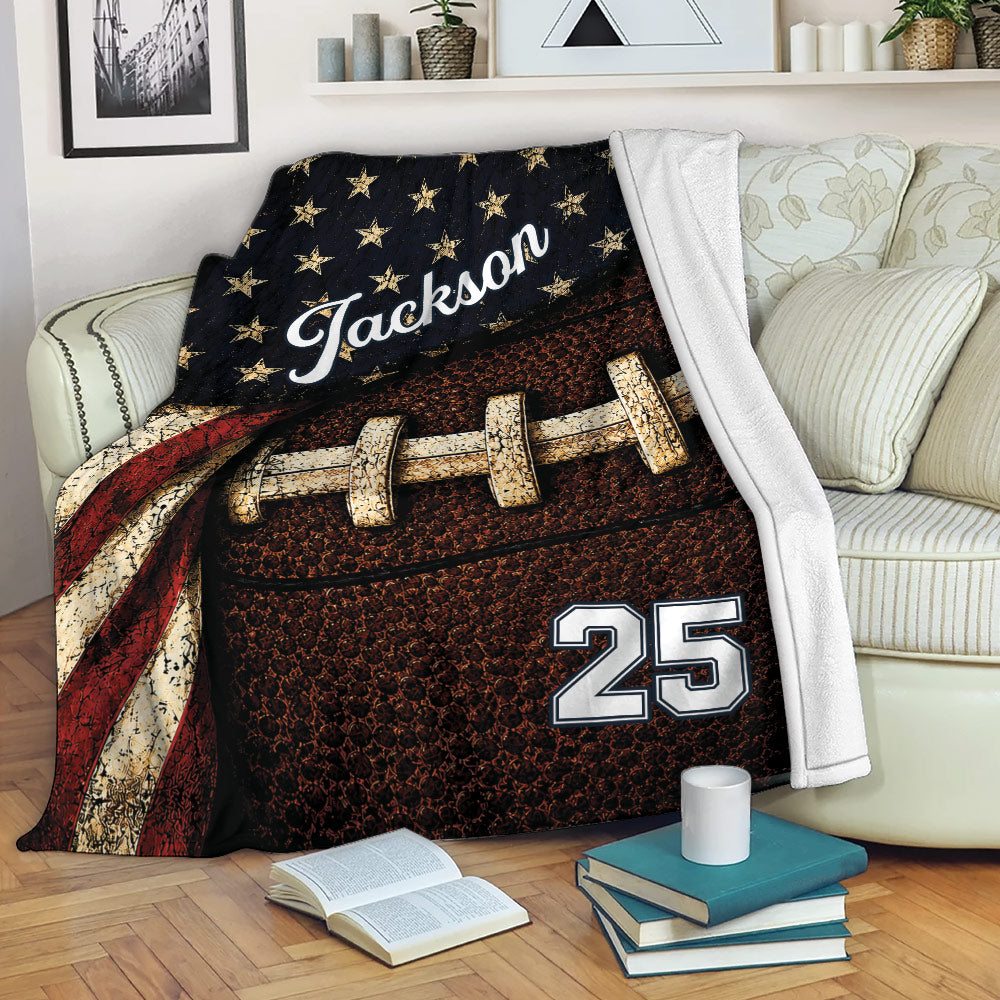 Football throw blanket draped over a sofa with patriotic stars, textured football artwork, and cozy decor