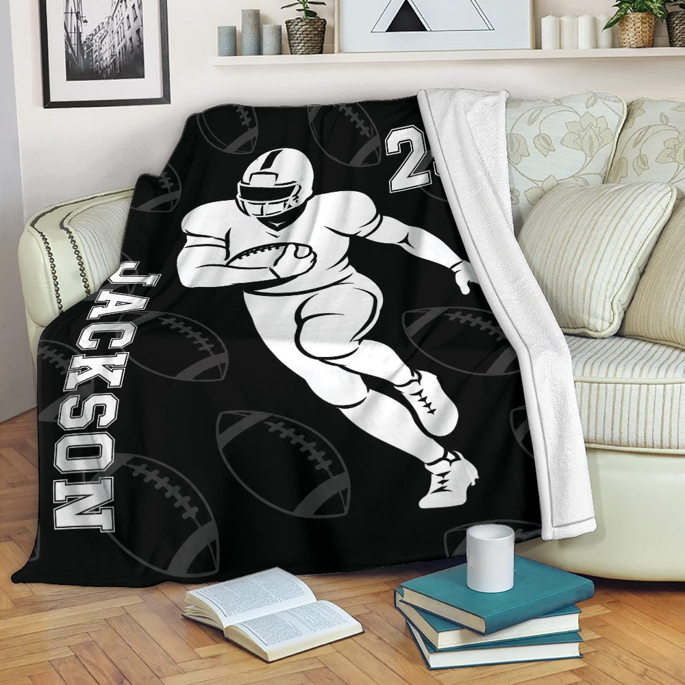 Football throw blanket displayed on a sofa with bold player artwork and black sports design