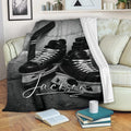 Hockey throw blanket displayed on a sofa with skates, stick, and puck artwork