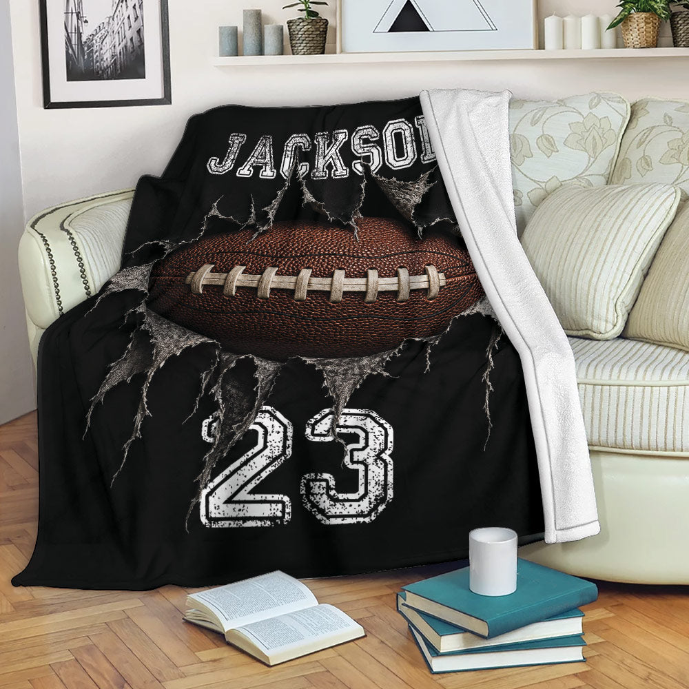 Football throw blanket displayed on a sofa with dramatic ripped fabric artwork and bold black and white sports graphics
