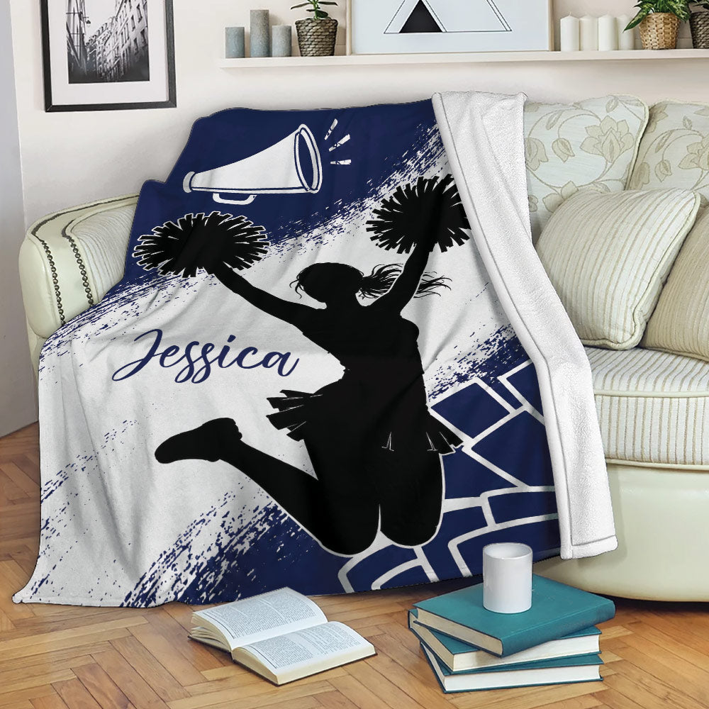 Cheerleading blanket draped over a sofa, featuring a cheerleader silhouette and navy blue pom-pom design