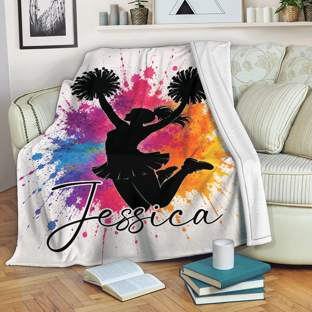 Cheerleading blanket draped over a sofa with a vibrant pom-pom silhouette design