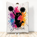 Cheerleading throw blanket with black cheerleader silhouette, pom-poms, and colorful paint splatter