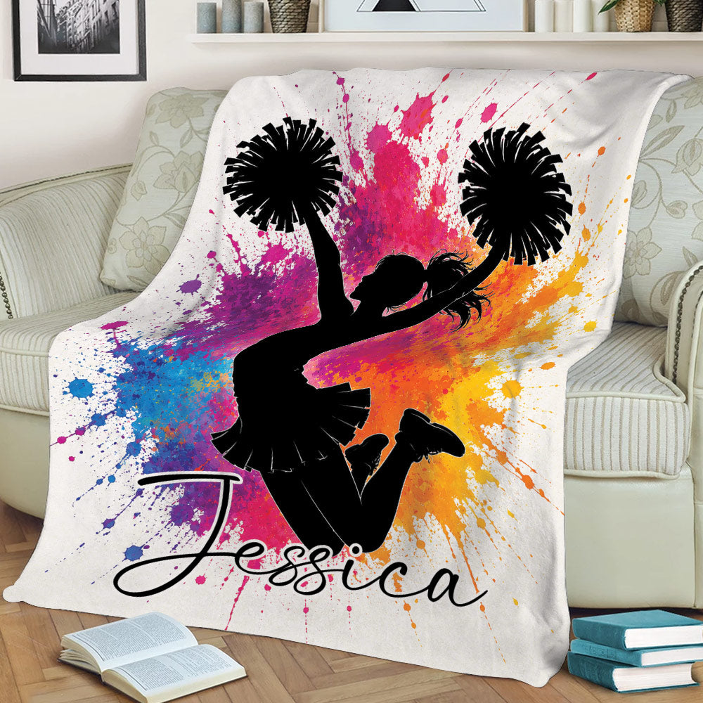 Colorful cheerleading throw blanket displayed on a sofa with a jumping cheerleader silhouette
