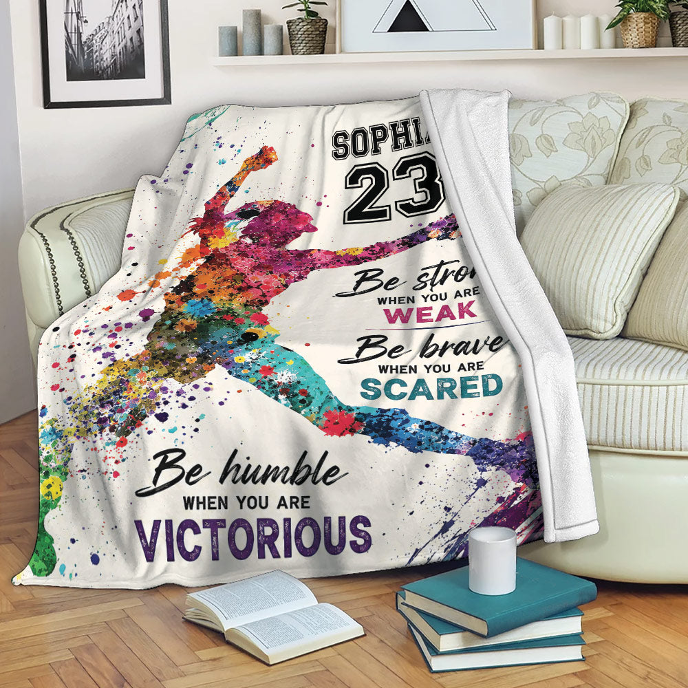 Colorful softball throw blanket displayed on a living room sofa
