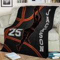 Basketball throw blanket styled over a sofa with dynamic player artwork and a dark orange-accented court theme