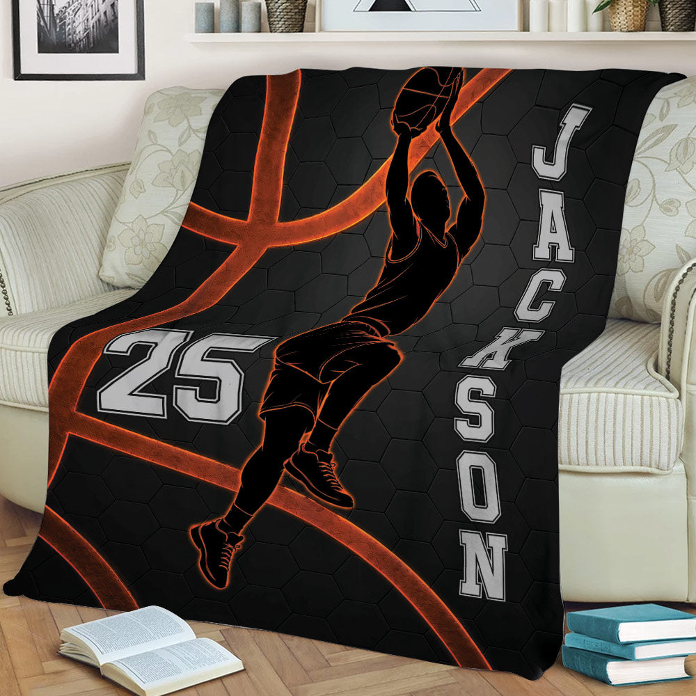 Basketball throw blanket styled over a sofa with dynamic player artwork and a dark orange-accented court theme