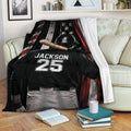 Baseball blanket displayed on a sofa with a helmeted player, bat, and patriotic flag design