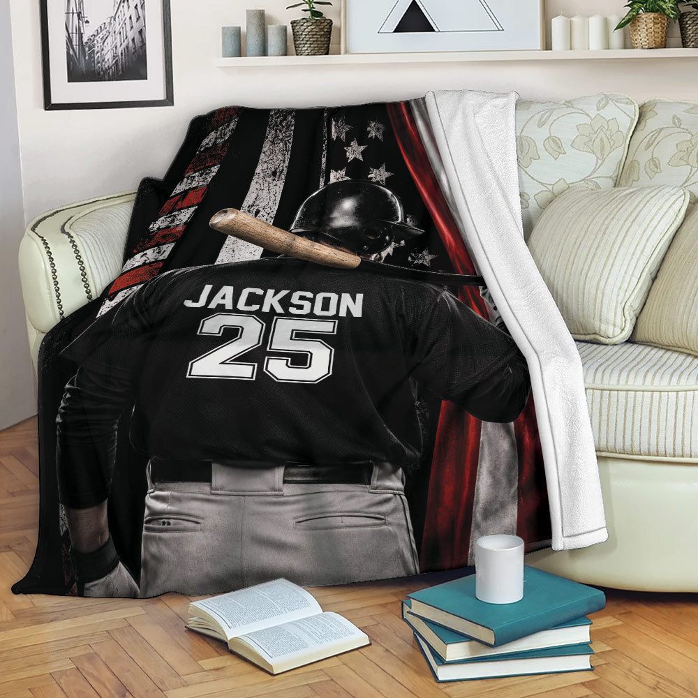 Baseball blanket displayed on a sofa with a helmeted player, bat, and patriotic flag design