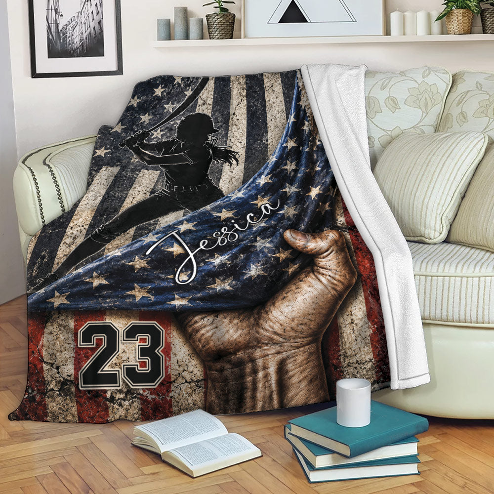 Patriotic softball blanket draped across a sofa with a female batter and star-spangled artwork
