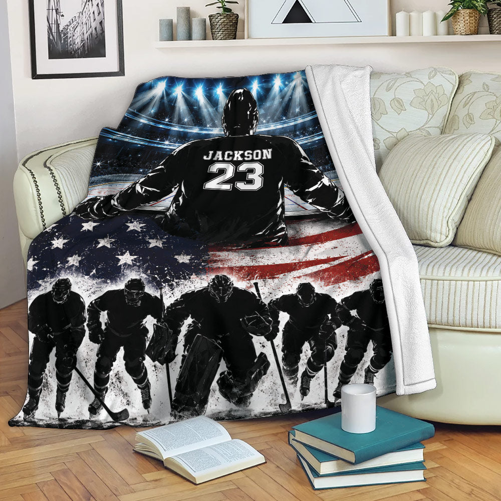 Patriotic hockey throw blanket displayed on a sofa with rink lights, hockey players, and American flag artwork