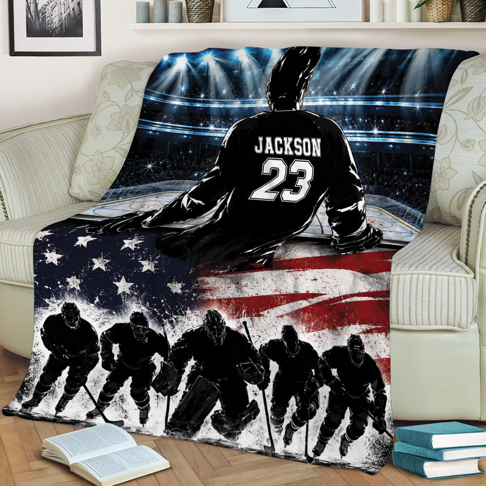 Hockey blanket draped across a couch with an ice rink scene, silhouetted players, and patriotic flag design