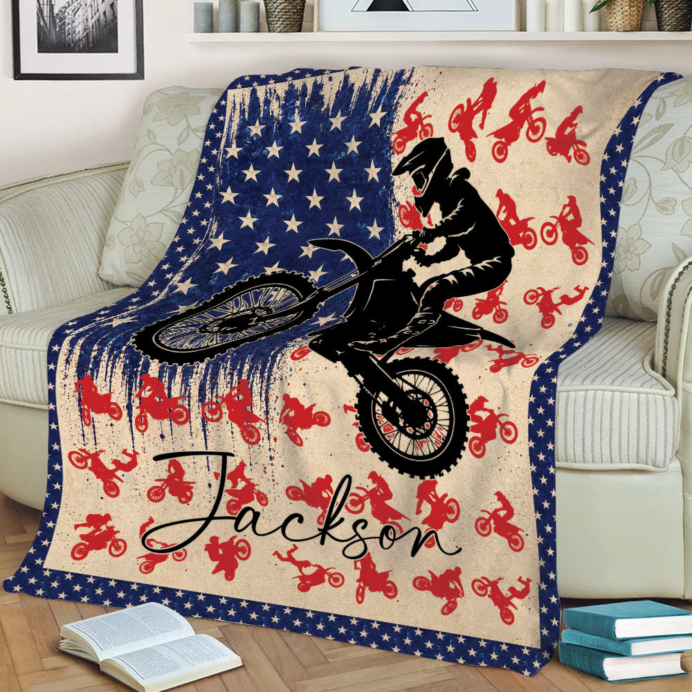 Motocross throw blanket displayed on a couch with a jumping dirt bike rider and star border