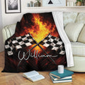 Racing throw blanket with checkered flags and flame artwork displayed on a living room sofa