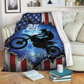 Motocross blanket draped over a sofa with dirt bike action artwork and patriotic red, white, and blue design