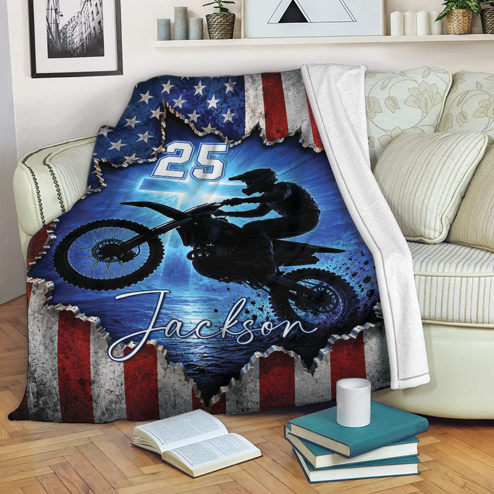 Motocross blanket draped over a sofa with dirt bike action artwork and patriotic red, white, and blue design