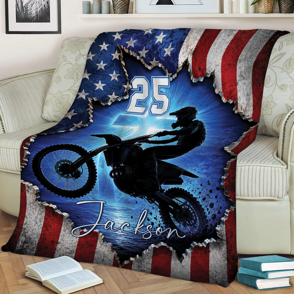 Motocross throw blanket displayed on a couch with silhouetted dirt bike rider and bold blue racing artwork