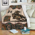 Barrel racing blanket displayed on a sofa with a horse and rider racing around a barrel