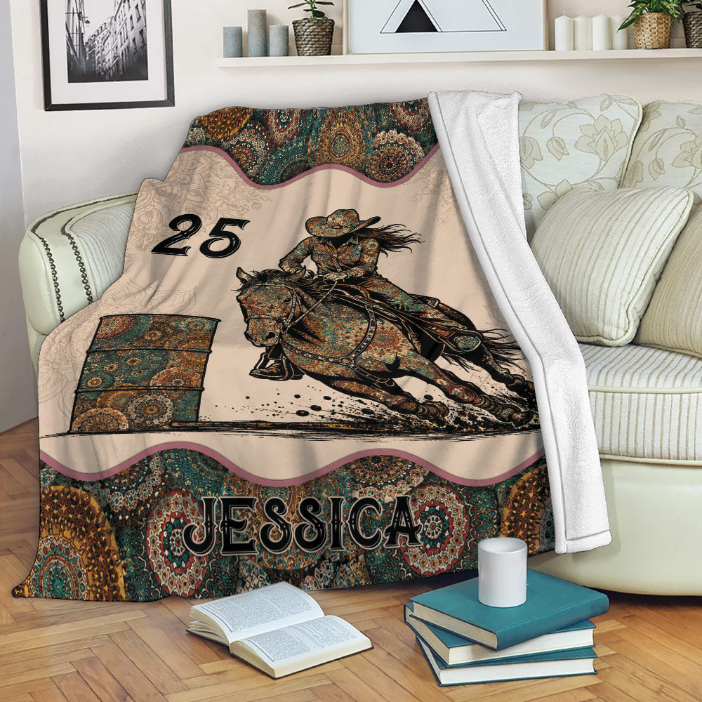 Barrel racing blanket displayed on a sofa with a horse and rider racing around a barrel