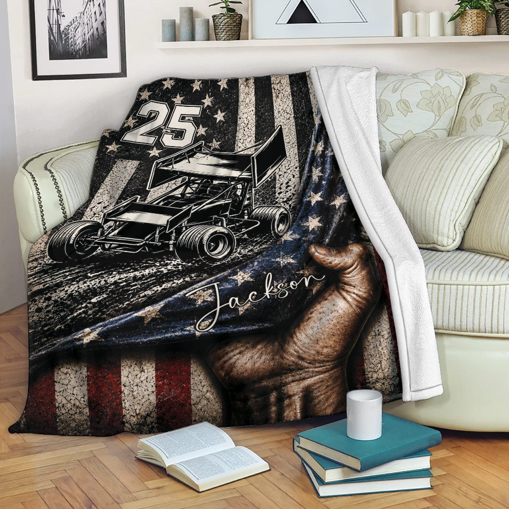 Custom dirt track racing throw blanket displayed on a sofa with sprint car artwork and distressed red, white, and blue design