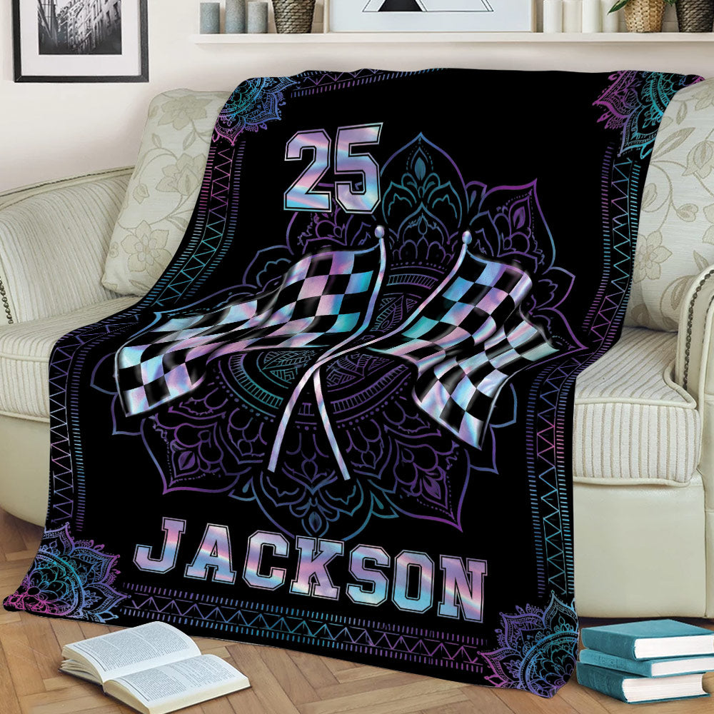 Racing throw blanket displayed on a couch with crossed flags and decorative blue and purple details