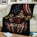 Wrestling blanket draped over a couch, featuring two grapplers, bold flag-inspired artwork, and a rugged distressed style