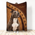 Pitbull throw blanket displayed upright with a brown leather-look background and paw print design