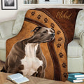 Pitbull throw blanket styled across a sofa with warm brown artwork and repeating paw prints