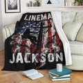 Patriotic lineman throw blanket displayed on a couch with utility worker artwork and black background