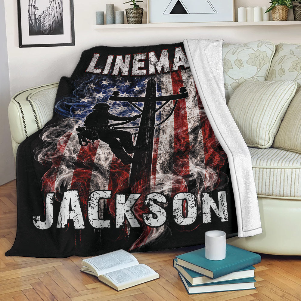 Patriotic lineman throw blanket displayed on a couch with utility worker artwork and black background