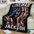 Lineman throw blanket draped over a sofa, featuring a powerline worker and distressed flag design