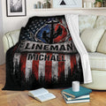 Patriotic lineman blanket displayed on a sofa with utility worker silhouettes and bold red, white, and blue artwork